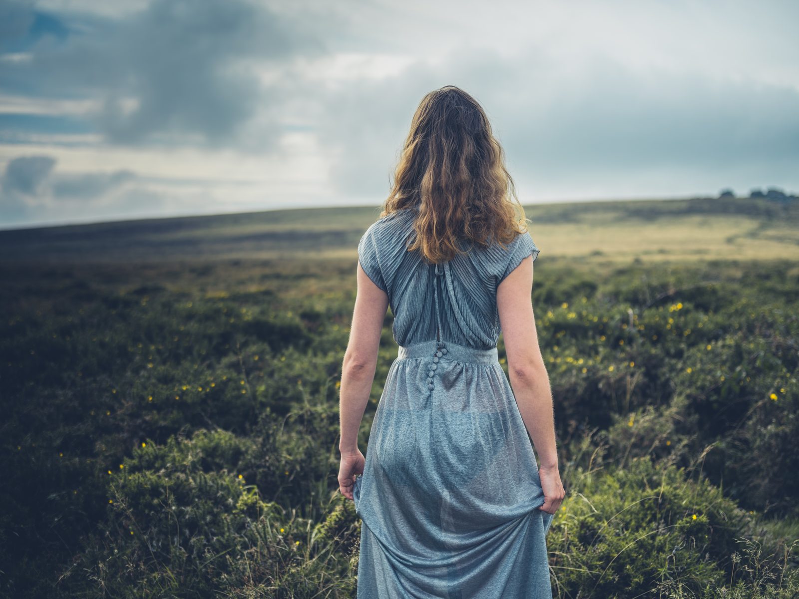 Woman in dress on the moor at golden hour — editorial fashion photography