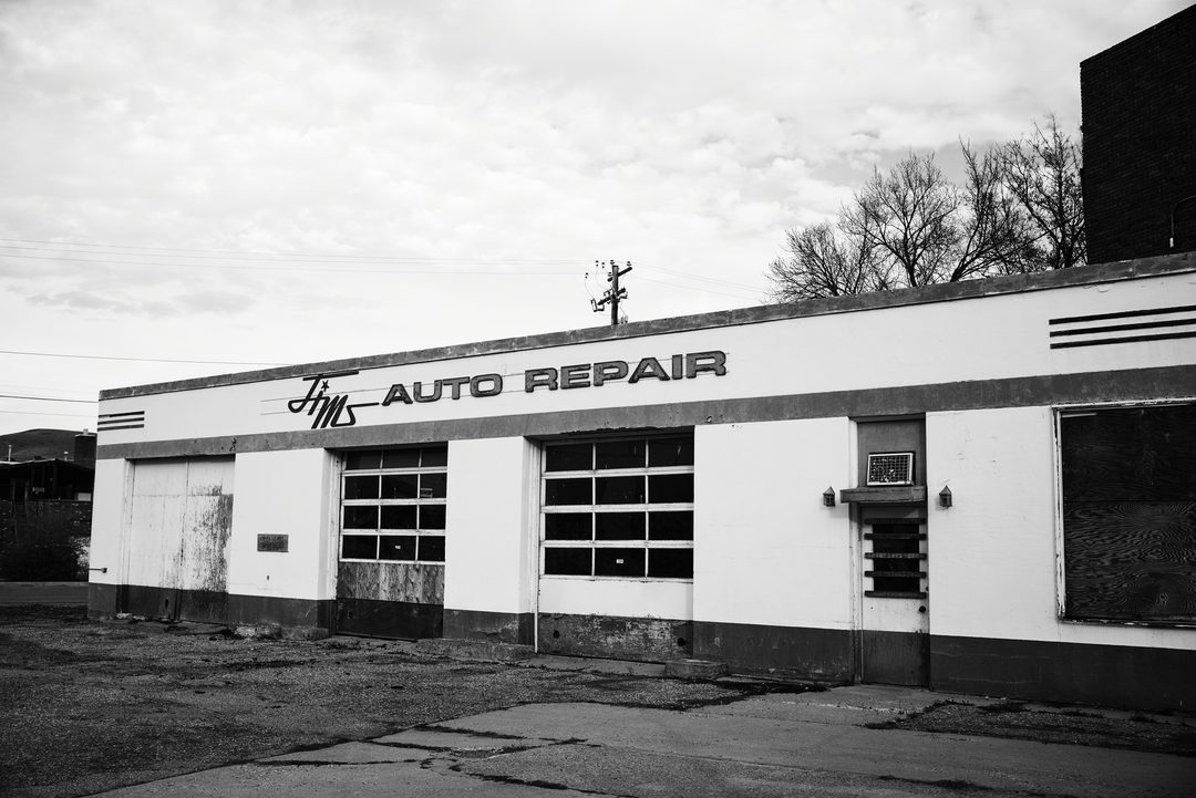 Jim's Auto Repair shop facade with vintage signage, black and white